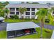 Condo building with carport parking and tropical landscaping at 1001 Tartan Dr # 207, Palm Harbor, FL 34684