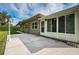 Exterior view of the home showcasing the rear patio, glass enclosed porch, and manicured lawn at 2342 Hazelwood Ln, Clearwater, FL 33763