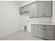 Laundry room with gray cabinets, white quartz countertops, and a terrazzo floor at 2709 W North B St # 1, Tampa, FL 33609