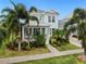 Stunning two-story light blue house with a porch and palm trees at 410 Islebay Dr, Apollo Beach, FL 33572