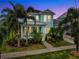 Beautiful two-story light blue house with a porch and lush landscaping at 410 Islebay Dr, Apollo Beach, FL 33572