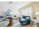 Bright living room with blue sofa, glass-top coffee table, and coastal decor at 12049 Hoosier Ct # 202, Hudson, FL 34667