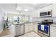 Open kitchen with granite counters, stainless steel appliances, and view of living room at 12049 Hoosier Ct # 202, Hudson, FL 34667