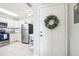 Bright kitchen entry with white cabinets, stainless steel appliances, and a decorative wreath at 12049 Hoosier Ct # 202, Hudson, FL 34667