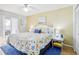 Main bedroom with king-size bed, coastal bedding, and balcony access at 12049 Hoosier Ct # 202, Hudson, FL 34667