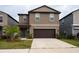 Two-story home with a two-car garage and landscaping at 10348 Blue Plume Ct, Riverview, FL 33578