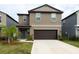 Two-story house with a two-car garage and landscaping at 10348 Blue Plume Ct, Riverview, FL 33578