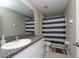 Clean bathroom with granite countertop, white vanity, and striped shower curtain at 10348 Blue Plume Ct, Riverview, FL 33578
