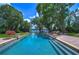Inviting swimming pool with brick patio and picturesque lake views at 7734 Still Lakes Dr, Odessa, FL 33556