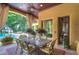 Covered patio with seating area, overlooking pool and lush landscaping at 7734 Still Lakes Dr, Odessa, FL 33556
