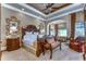 Spacious Primary bedroom boasts a king-size bed and sitting area with large windows at 7734 Still Lakes Dr, Odessa, FL 33556