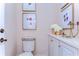 Elegant powder room with pedestal sink, decorative accents, and built-in storage at 7734 Still Lakes Dr, Odessa, FL 33556