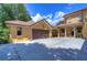 Two-car garage with wood doors and a charming courtyard entry at 7734 Still Lakes Dr, Odessa, FL 33556