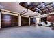 Three-car garage with wood-like paneling and high ceilings at 7734 Still Lakes Dr, Odessa, FL 33556