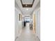 Hallway view showing neutral paint and tile floors with view into a water-view living space at 17745 Gulf Blvd # 604, Redington Shores, FL 33708