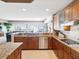 Gourmet kitchen featuring wood cabinets, granite countertops, a center island, and stainless steel appliances at 17745 Gulf Blvd # 604, Redington Shores, FL 33708