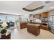 Gourmet kitchen with wood cabinets, center island, granite countertops, and stainless steel appliances at 17745 Gulf Blvd # 604, Redington Shores, FL 33708