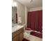 Clean bathroom with a burgundy shower curtain and wood vanity at 18833 Bent Pine Dr, Hudson, FL 34667