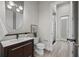 Modern bathroom featuring a dark vanity, decorative mirror and walk-in shower at 2905 Safe Harbor Dr, Tampa, FL 33618