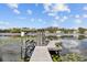 Steps down to a lakefront dock with a covered seating area and planters at 2905 Safe Harbor Dr, Tampa, FL 33618