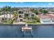 Aerial shot of a modern home on the water with a dock and boat lift surrounded by lush landscaping and trees at 7949 2Nd S Ave, St Petersburg, FL 33707