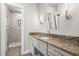 Bathroom featuring a granite countertop vanity, modern lighting, and a glass-enclosed shower at 7949 2Nd S Ave, St Petersburg, FL 33707