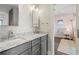 Bright bathroom featuring double sinks with granite counters and modern fixtures, adjacent to a cute bedroom at 7949 2Nd S Ave, St Petersburg, FL 33707