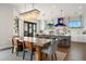 Bright dining area with a long table, stylish chairs, and a modern chandelier adjacent to an open concept kitchen at 7949 2Nd S Ave, St Petersburg, FL 33707