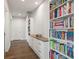 Hallway with custom built-in bookshelves and storage, and hardwood floors at 7949 2Nd S Ave, St Petersburg, FL 33707