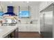 Gourmet kitchen with a stainless steel stove, custom cabinets, granite countertops, and glass shelving at 7949 2Nd S Ave, St Petersburg, FL 33707