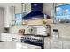 Well-appointed kitchen featuring blue appliances, granite countertops, glass shelving, and stainless steel accents at 7949 2Nd S Ave, St Petersburg, FL 33707
