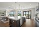 Spacious open-concept kitchen flows to dining and living areas, with an island, stainless appliances, and modern lighting at 7949 2Nd S Ave, St Petersburg, FL 33707