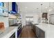 Modern kitchen features stainless steel appliances, double sinks, a large island and a striking blue range hood at 7949 2Nd S Ave, St Petersburg, FL 33707