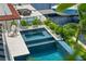A luxury pool features multiple levels surrounded by lush plants and views of the boat dock at 7949 2Nd S Ave, St Petersburg, FL 33707