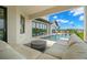 Patio view featuring an outdoor seating area with a fireplace that leads to a pool with stepping stones and lounge chairs at 7949 2Nd S Ave, St Petersburg, FL 33707