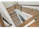 A modern wooden staircase with metal cable railing at 7949 2Nd S Ave, St Petersburg, FL 33707