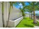 Backyard featuring a modern water feature alongside lush tropical landscaping and waterfront views at 7949 2Nd S Ave, St Petersburg, FL 33707