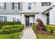 Townhome front entry with dark door, landscaping and walkway at 14929 Promenade Pkwy, Odessa, FL 33556