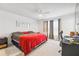 Spacious main bedroom with a king-size bed and red blanket at 14929 Promenade Pkwy, Odessa, FL 33556