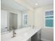 Double vanity bathroom with a large mirror and window at 10341 Fieldstone Myrtle Way, San Antonio, FL 33576