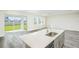 Modern kitchen with a large island, stainless steel sink, and white quartz countertops at 10341 Fieldstone Myrtle Way, San Antonio, FL 33576