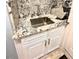 Bathroom vanity with a stainless sink, granite countertops and white cabinets at 10411 Riverburn Dr, Tampa, FL 33647