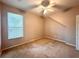 Neutral bedroom with a large window letting in light with a ceiling fan and tan carpet at 10411 Riverburn Dr, Tampa, FL 33647