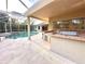 Outdoor kitchen and covered patio next to screened pool and jacuzzi at 10411 Riverburn Dr, Tampa, FL 33647