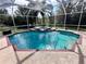 Relaxing screened pool and jacuzzi area with a brick trim and tropical plants at 10411 Riverburn Dr, Tampa, FL 33647
