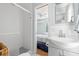Clean bathroom with shower, gray vanity, and view into bedroom at 19718 Gulf Blvd, Indian Shores, FL 33785