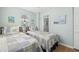 Twin bedroom with light blue walls, and comfortable bedding at 19718 Gulf Blvd, Indian Shores, FL 33785