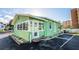 Quaint beach cottage with green exterior and private parking at 19718 Gulf Blvd, Indian Shores, FL 33785