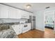 Modern kitchen with white cabinets, granite countertops and stainless steel appliances at 19718 Gulf Blvd, Indian Shores, FL 33785