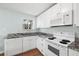 Modern white kitchen with granite countertops and stainless steel appliances at 19718 Gulf Blvd, Indian Shores, FL 33785